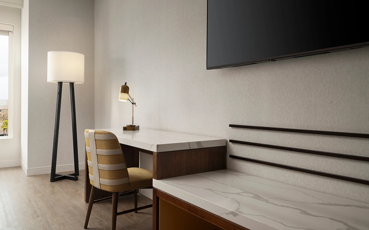 Hotel room desk area and flatscreen TV.