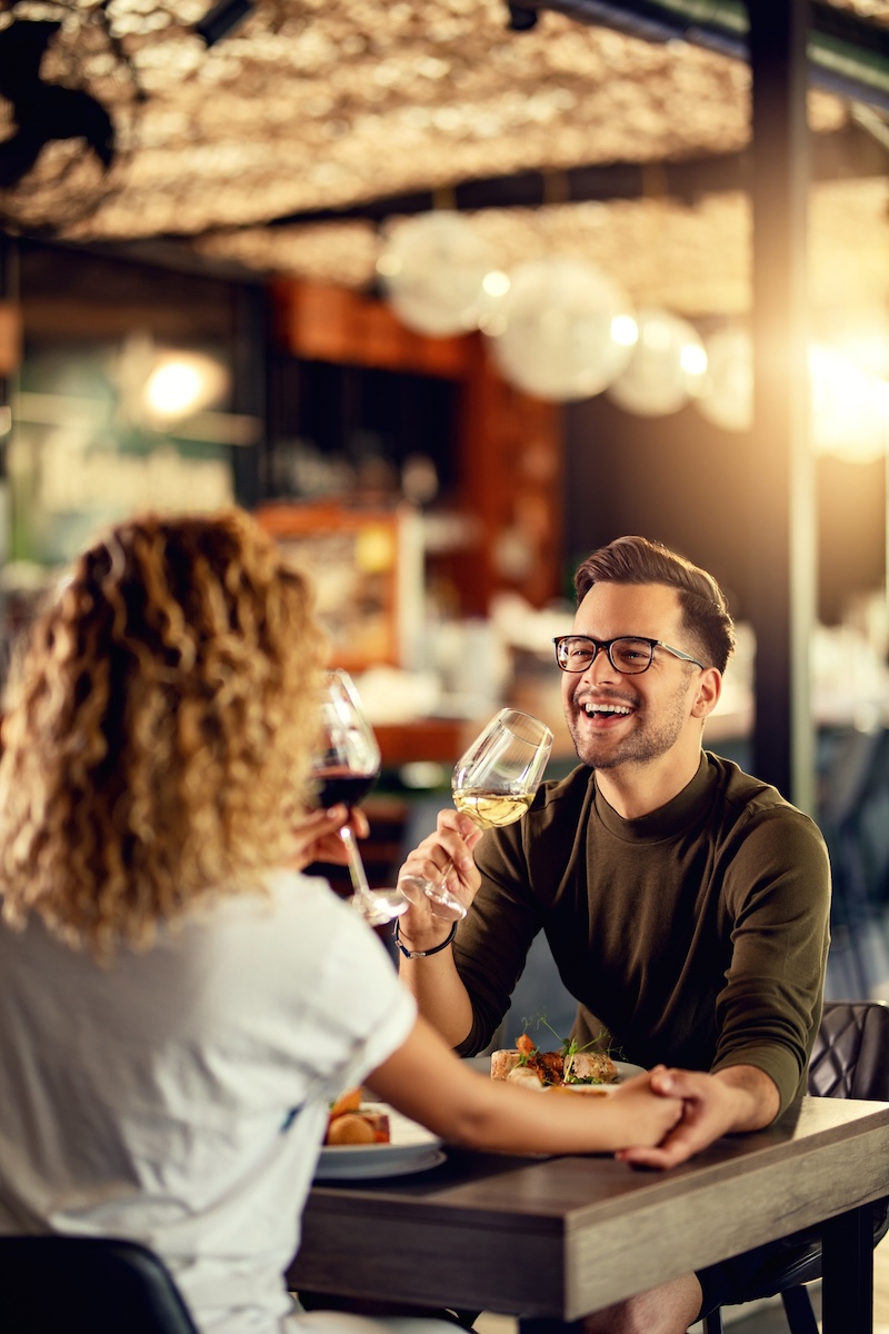 Man smiling holding glass of wine