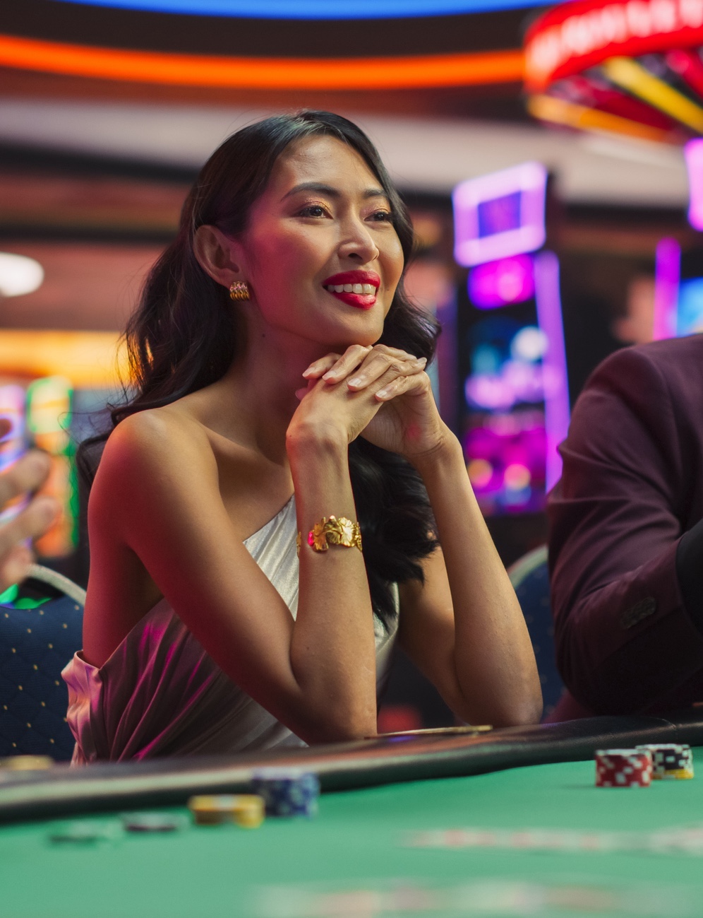 Woman smiling sitting at a craps table in a casino.